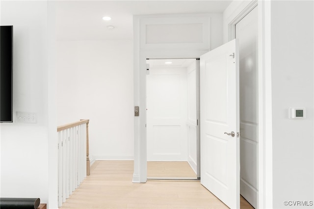 corridor with recessed lighting, baseboards, and light wood finished floors