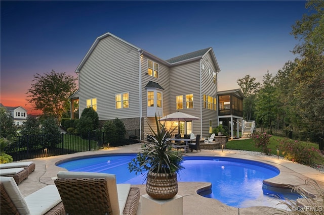 view of swimming pool featuring a patio, fence, a yard, a fenced in pool, and stairs