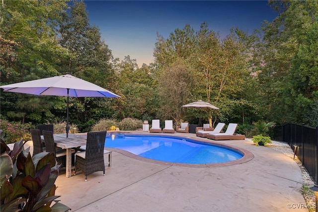 pool with outdoor dining area, a patio, and fence