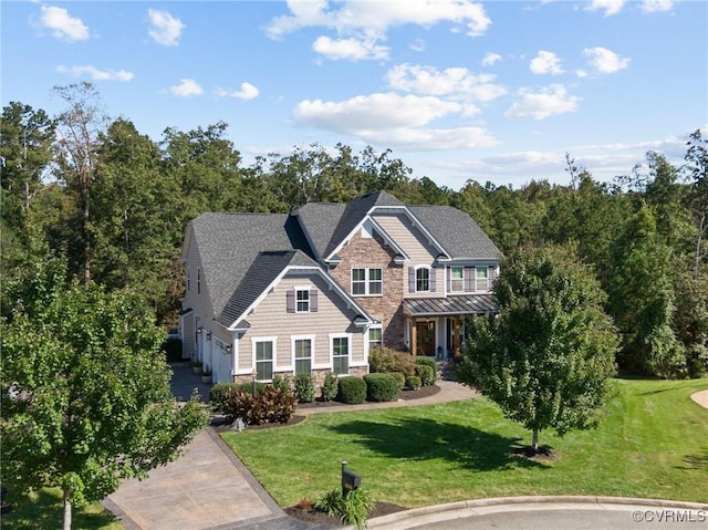 view of front facade with stone siding, driveway, an attached garage, and a front yard