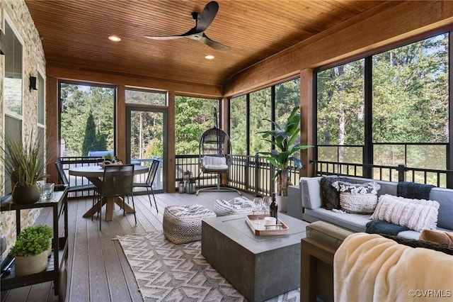 sunroom / solarium featuring a ceiling fan, plenty of natural light, and wood ceiling