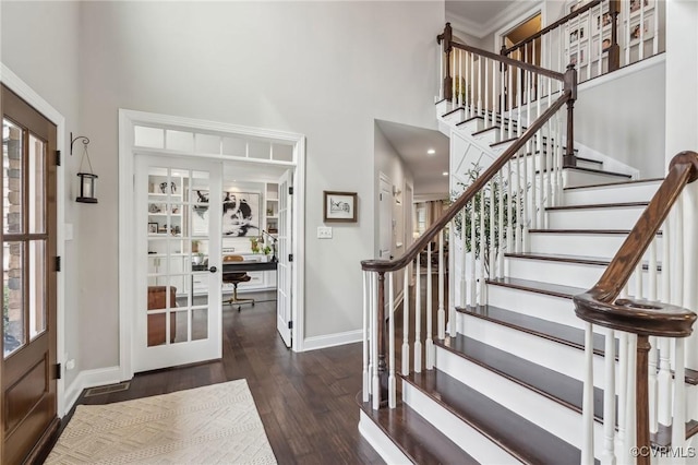 entrance foyer featuring wood finished floors, french doors, baseboards, and a towering ceiling