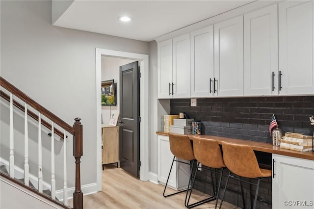 bar with baseboards, recessed lighting, decorative backsplash, stairs, and light wood-type flooring