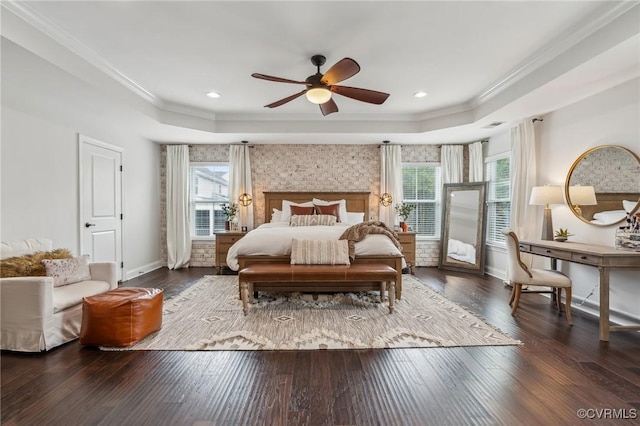 bedroom featuring a raised ceiling, crown molding, baseboards, and wood-type flooring