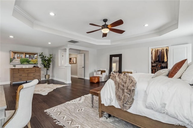 bedroom with recessed lighting, a tray ceiling, visible vents, and wood finished floors