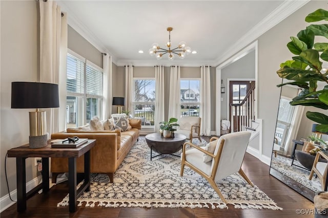 living area with baseboards, an inviting chandelier, wood finished floors, and crown molding