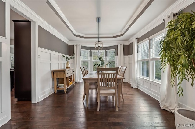 dining room with a decorative wall, plenty of natural light, and a raised ceiling