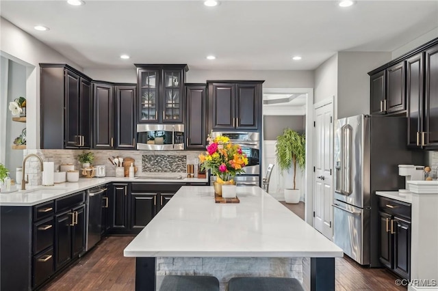 kitchen with dark wood finished floors, light countertops, stainless steel appliances, and a sink