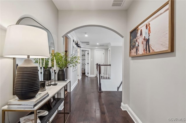 corridor featuring visible vents, baseboards, dark wood finished floors, an upstairs landing, and recessed lighting