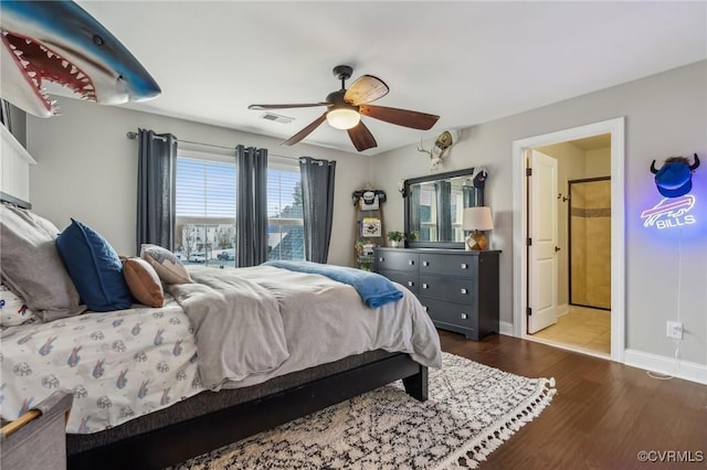 bedroom featuring visible vents, a ceiling fan, wood finished floors, connected bathroom, and baseboards