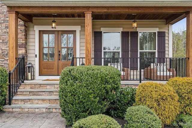 view of exterior entry with stone siding and a porch