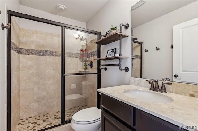 bathroom featuring vanity, toilet, and a shower stall