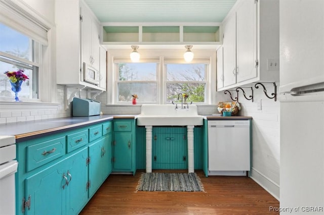 kitchen with dark wood-style floors, backsplash, white appliances, and a sink