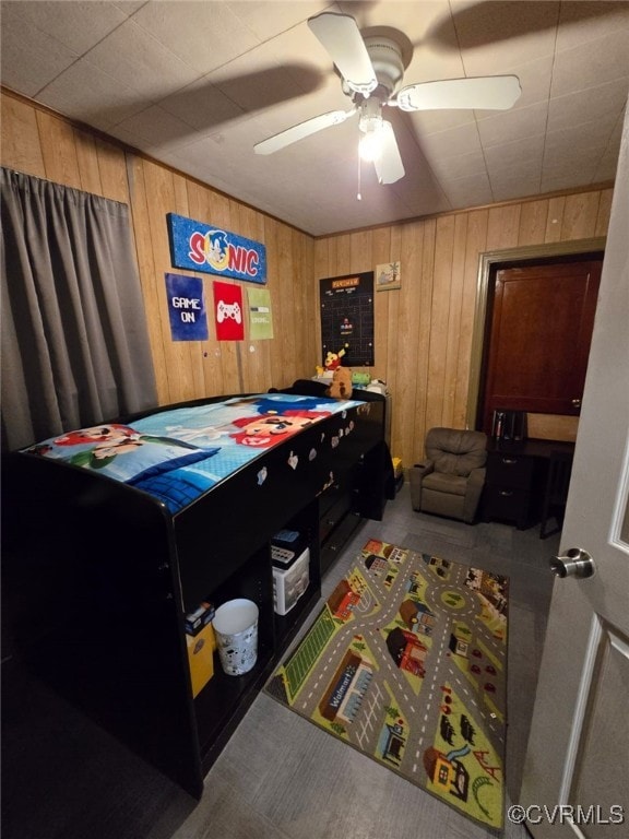 bedroom with wooden walls and a ceiling fan