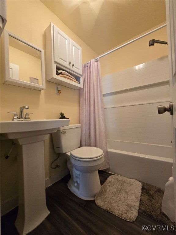 bathroom with shower / bath combination with curtain, toilet, wood finished floors, and a sink