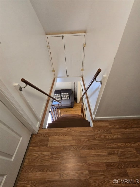 stairway with baseboards and wood finished floors