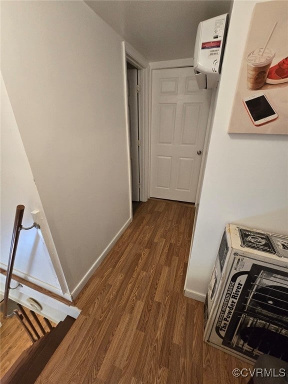 corridor with dark wood finished floors and baseboards