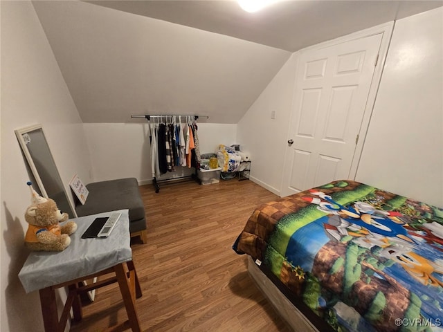 bedroom featuring vaulted ceiling, baseboards, and wood finished floors