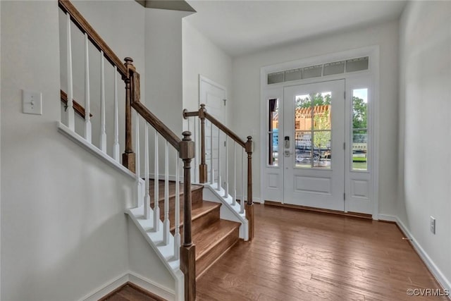 entryway with stairway, baseboards, and hardwood / wood-style floors