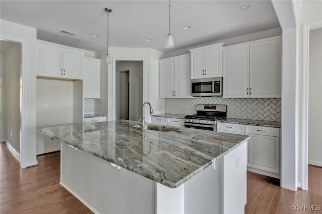 kitchen featuring a sink, wood finished floors, appliances with stainless steel finishes, and white cabinets