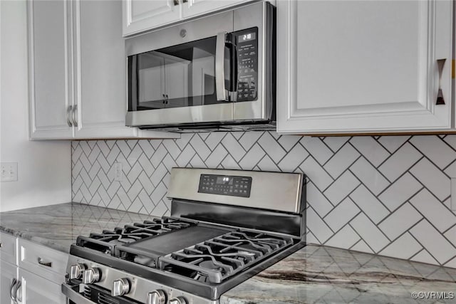 kitchen featuring light stone counters, backsplash, white cabinetry, and stainless steel appliances