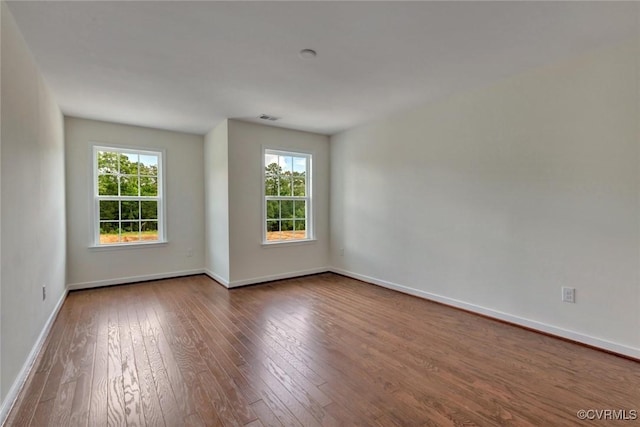 empty room with baseboards and wood-type flooring