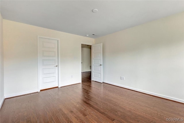 unfurnished bedroom featuring baseboards and dark wood finished floors