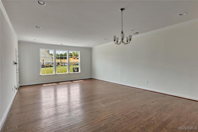 unfurnished room with an inviting chandelier, wood finished floors, and ornamental molding