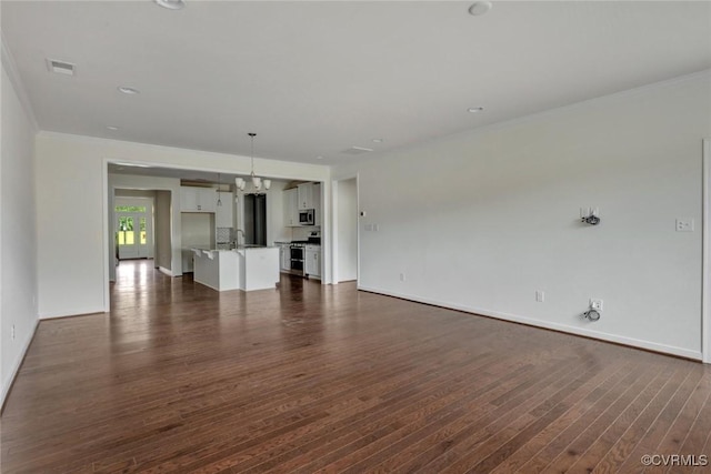 unfurnished living room with visible vents, baseboards, dark wood-style floors, and ornamental molding