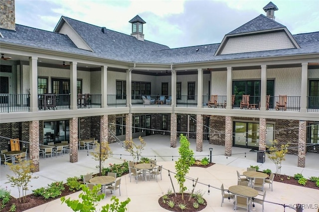 back of house with a patio area, outdoor dining space, and brick siding