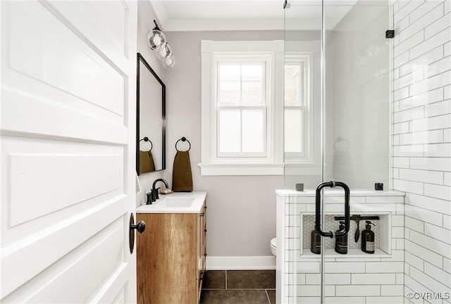 bathroom with tile patterned flooring, baseboards, toilet, a stall shower, and vanity