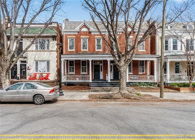 multi unit property featuring brick siding and a porch