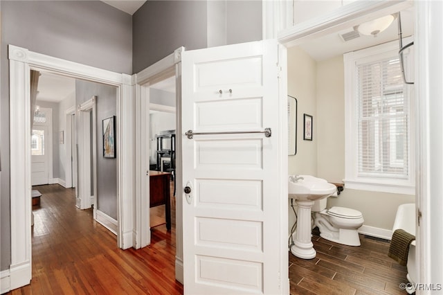 bathroom with baseboards, toilet, and wood finished floors