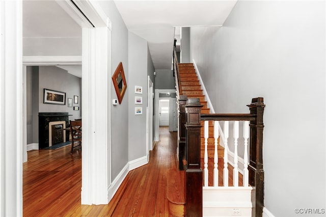 corridor featuring stairway, baseboards, and wood finished floors