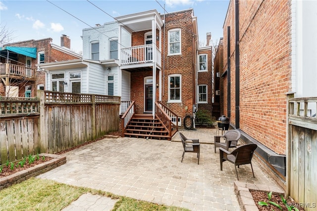 back of property featuring a patio, fence, and brick siding