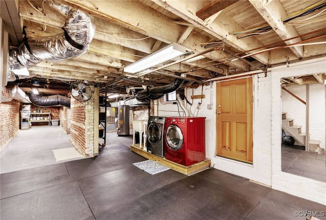 unfinished basement featuring stairway, water heater, brick wall, and washing machine and clothes dryer