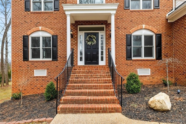 view of exterior entry featuring brick siding