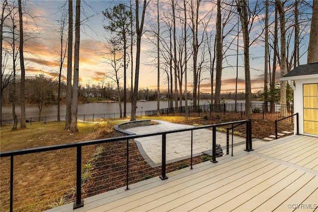 deck with a water view and a fenced backyard