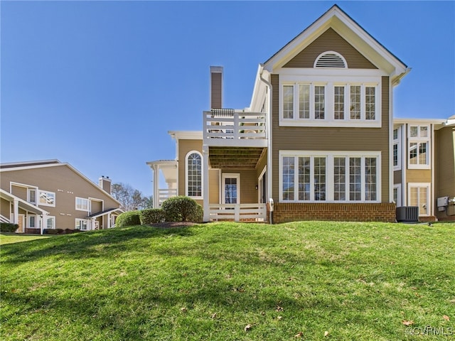 back of property featuring a yard, brick siding, and cooling unit