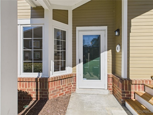 doorway to property featuring brick siding