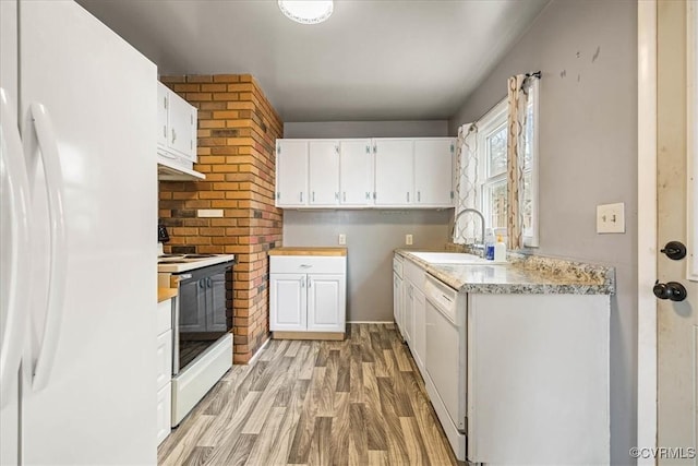 kitchen featuring a sink, under cabinet range hood, white cabinetry, white appliances, and light wood finished floors