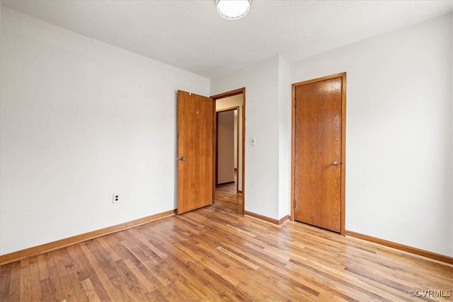 unfurnished room with light wood-style flooring and baseboards