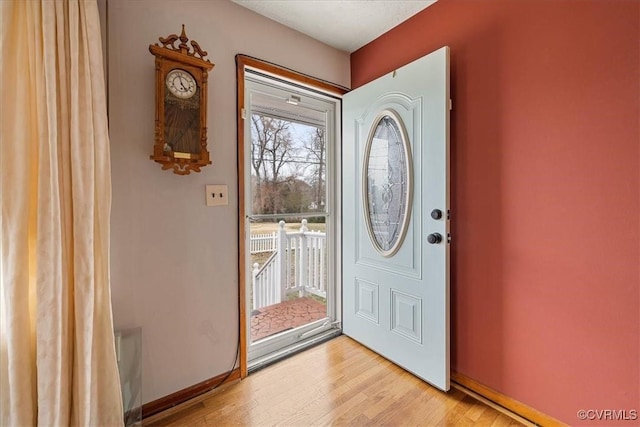 foyer featuring light wood-style floors and baseboards