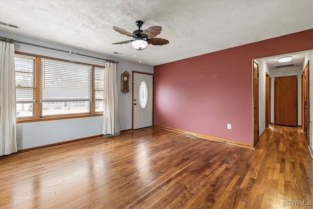 unfurnished room featuring visible vents, a textured ceiling, and wood finished floors