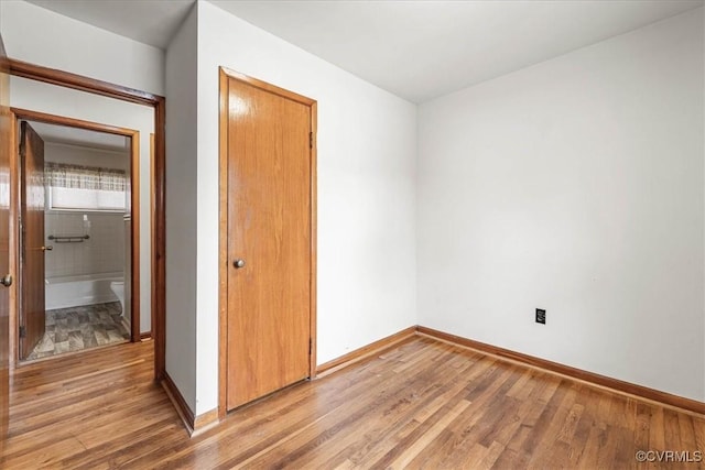 empty room with baseboards and light wood-style floors