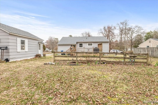 rear view of property with a yard and fence