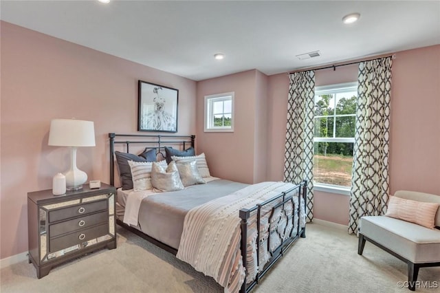 bedroom featuring visible vents, light carpet, and baseboards