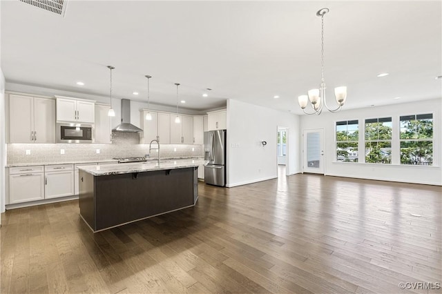 kitchen featuring visible vents, dark wood-type flooring, open floor plan, stainless steel appliances, and wall chimney range hood