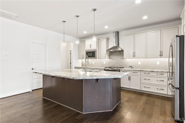 kitchen featuring a sink, freestanding refrigerator, wall chimney range hood, built in microwave, and range