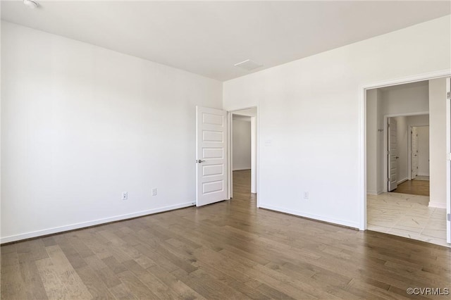 unfurnished room featuring baseboards and wood finished floors